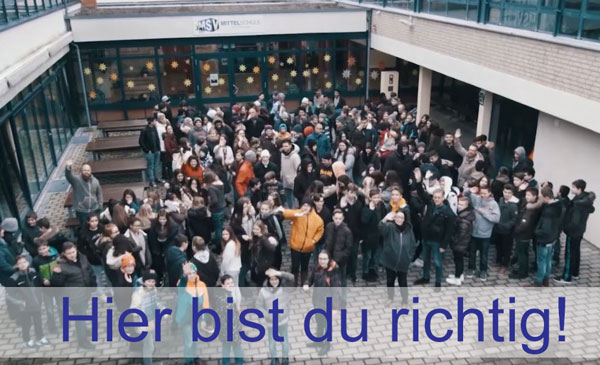 Schüler und Lehrer im Innenhof der Schule